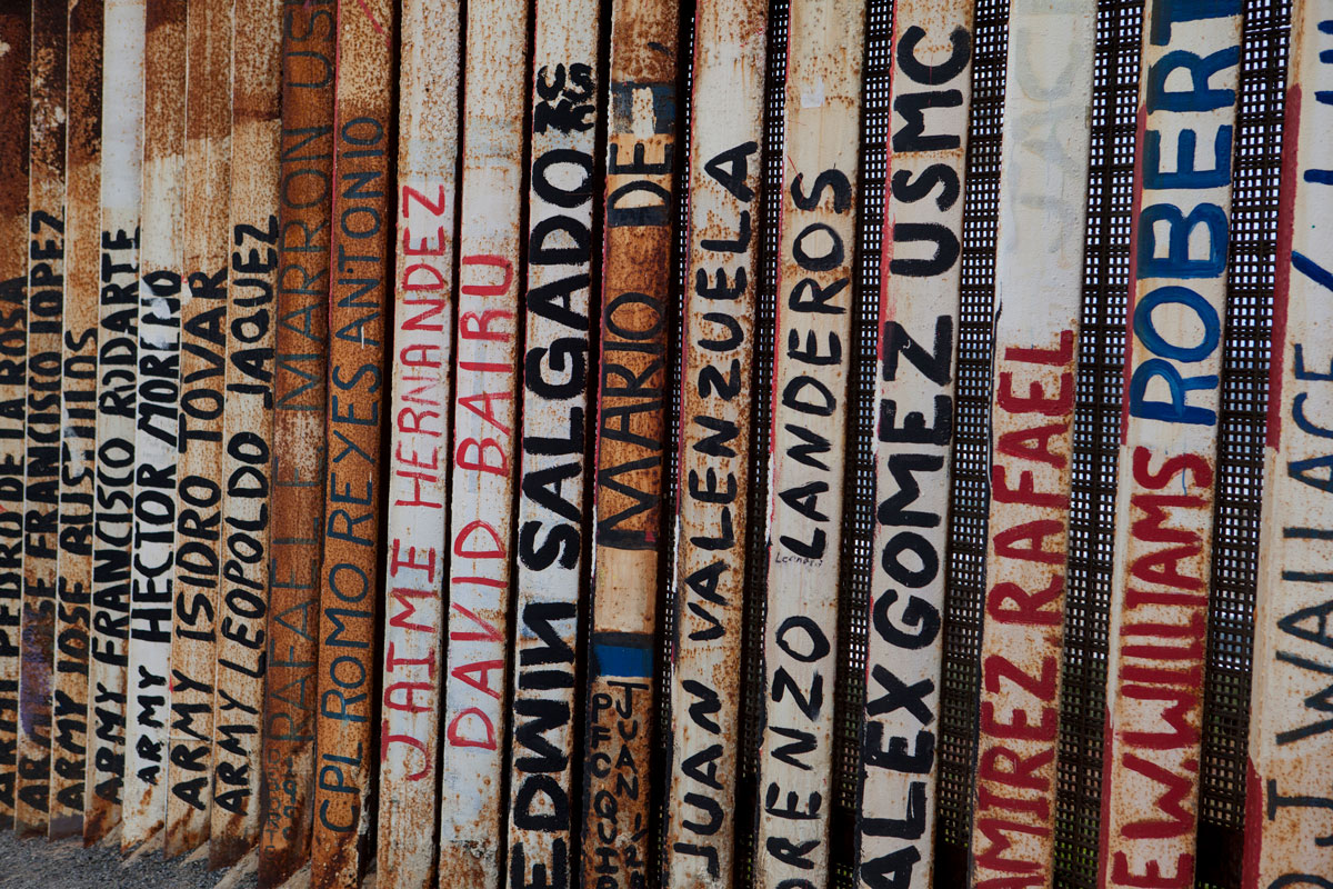 A section of the U.S-Mexico border wall is painted with art and the names of deported U.S. veterans in Tijuana.