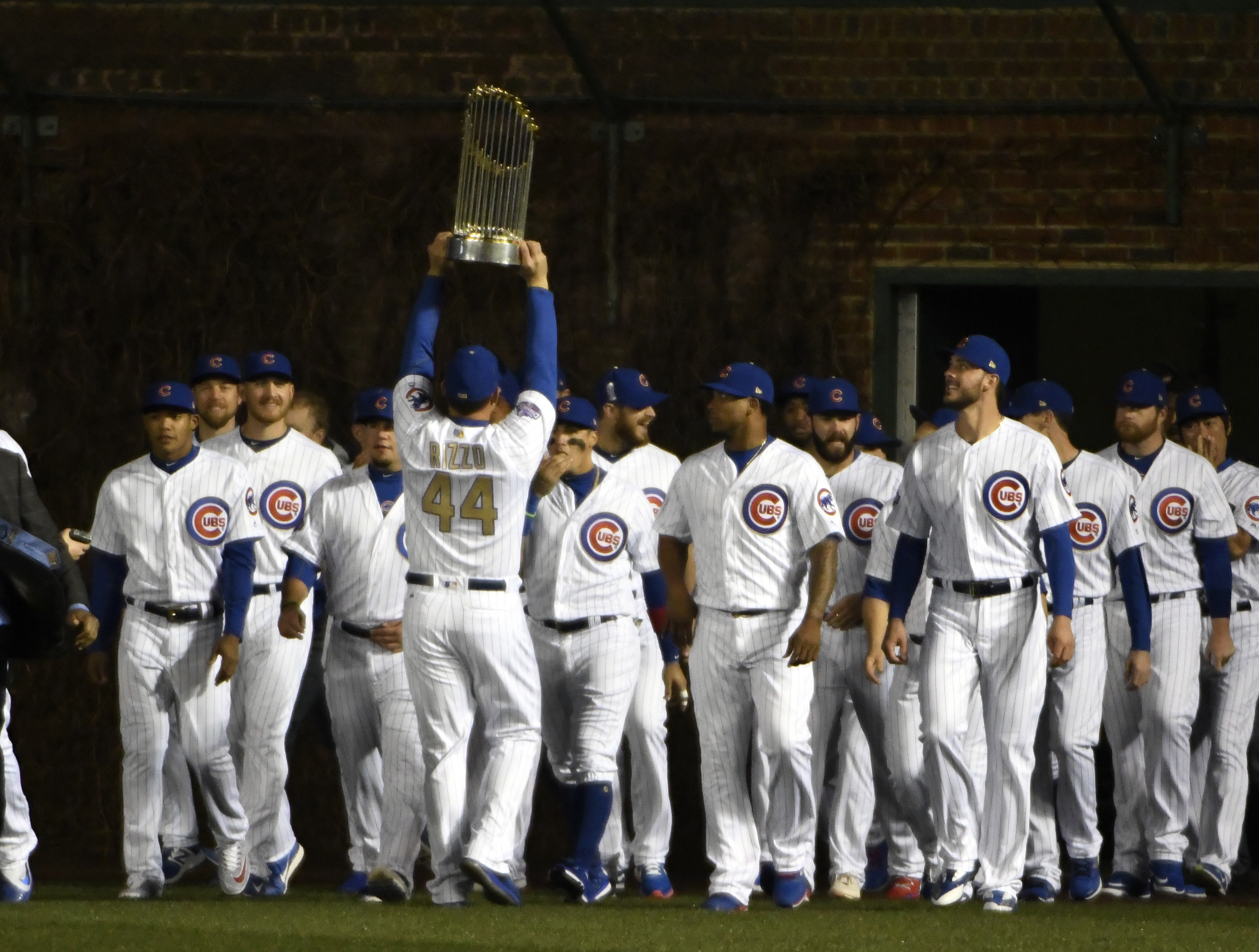 Cubs first baseman Anthony Rizzo (44) carries the 2016 World Series Championship trophy onto the field after the Cubs took turns raising the team's first championship banner in 108 years. (AP Photo/David Banks)